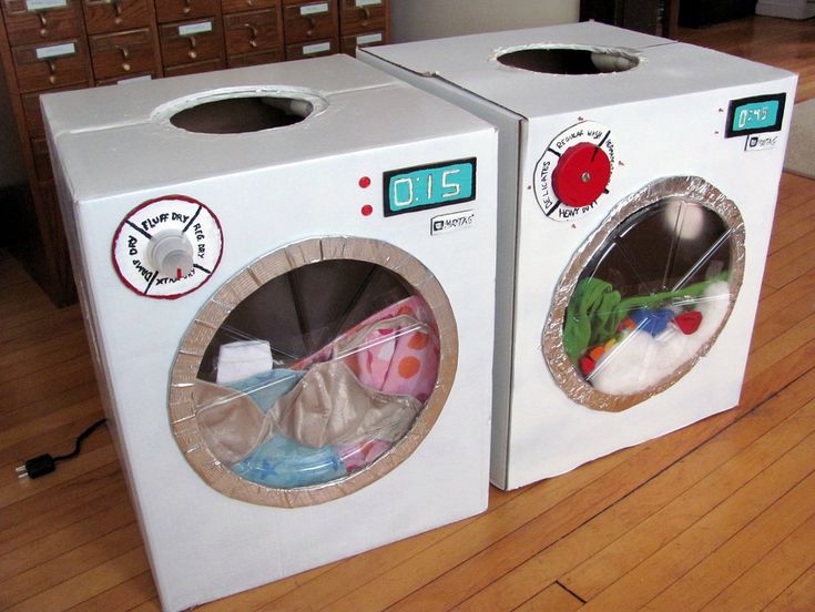 two washing machines sitting on top of a wooden floor