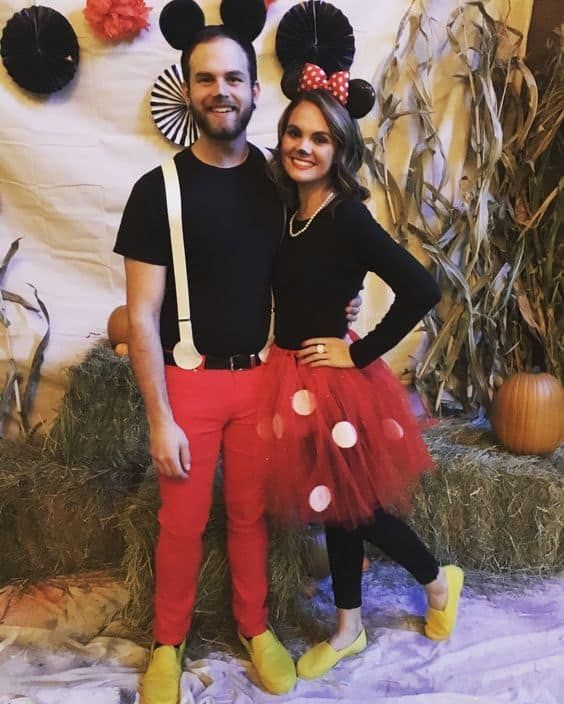 a man and woman in mickey mouse costumes