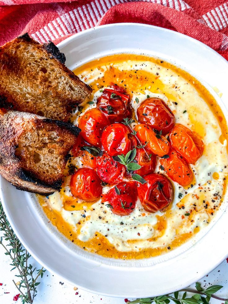 a white bowl filled with soup and two pieces of bread