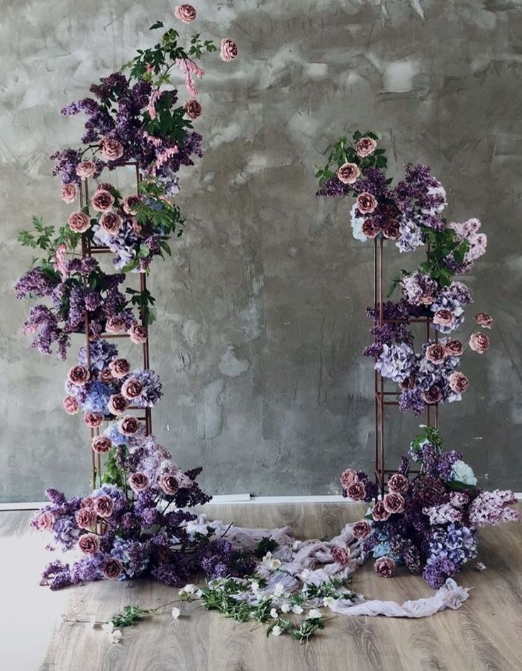 an arrangement of purple flowers on a wooden floor