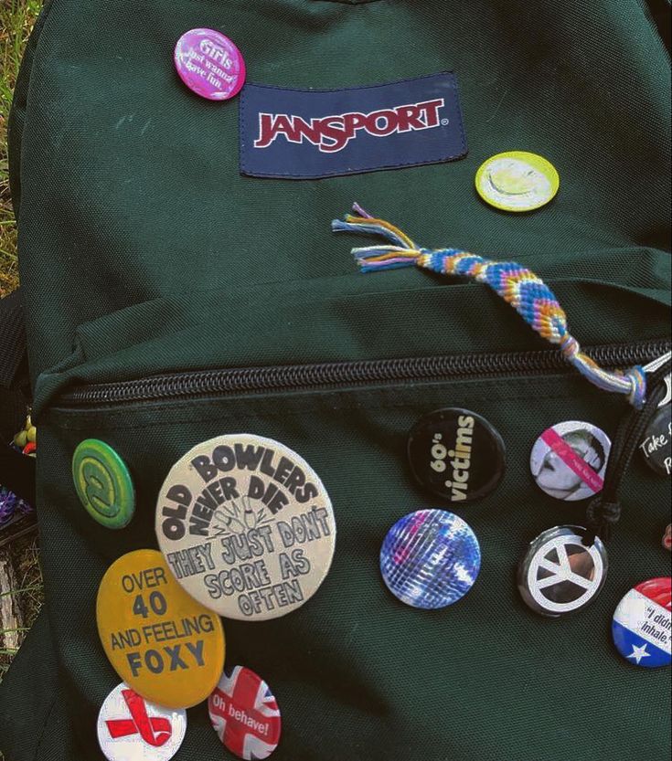 Cool Backpacks Aesthetic, Cool Backpack Aesthetic, Pins For Backpacks Aesthetic, Pin Covered Backpack, Black Jansport Backpacks Aesthetic Pins, Badges On Backpacks, Green Jansport Backpack Aesthetic, Old Backpack Aesthetic, Cute Pins For Backpacks Aesthetic