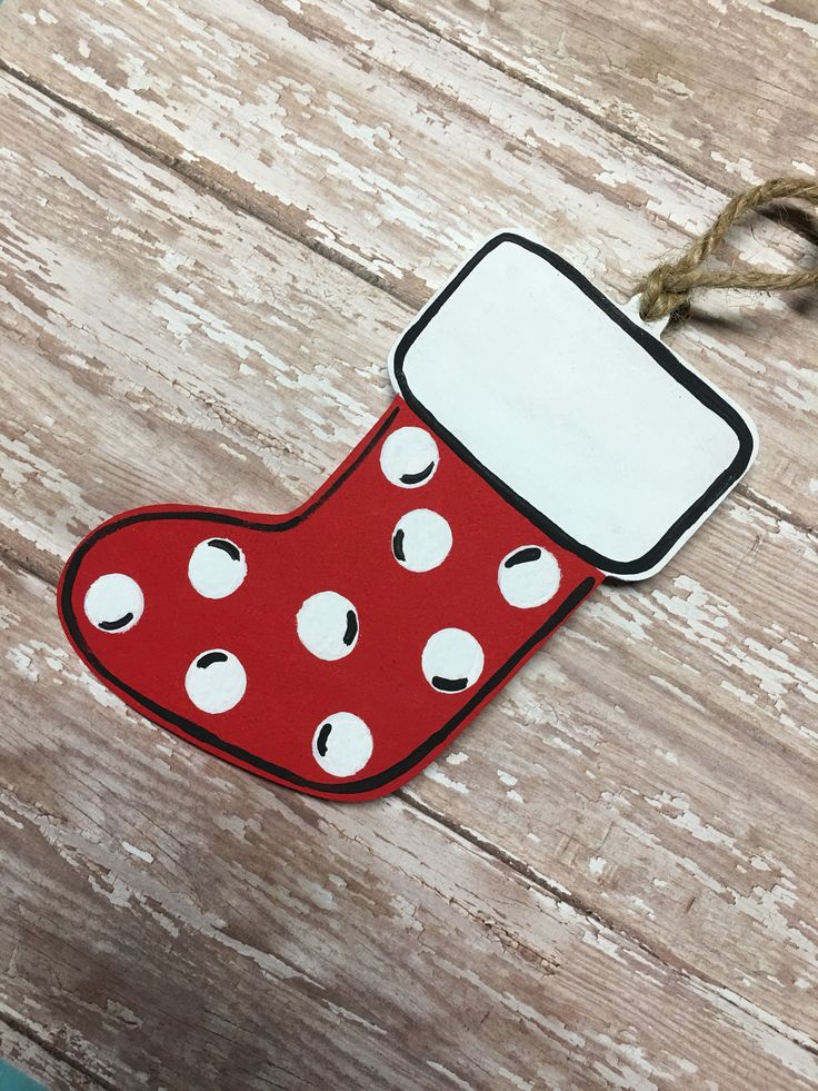 a christmas stocking ornament hanging on a wooden table with a string attached to it