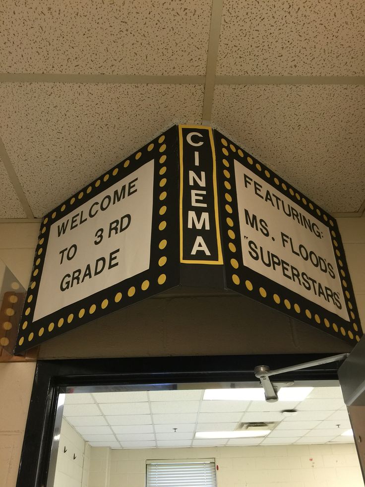 a sign hanging from the side of a building that says cinema to 3rd grade and 3rd grade