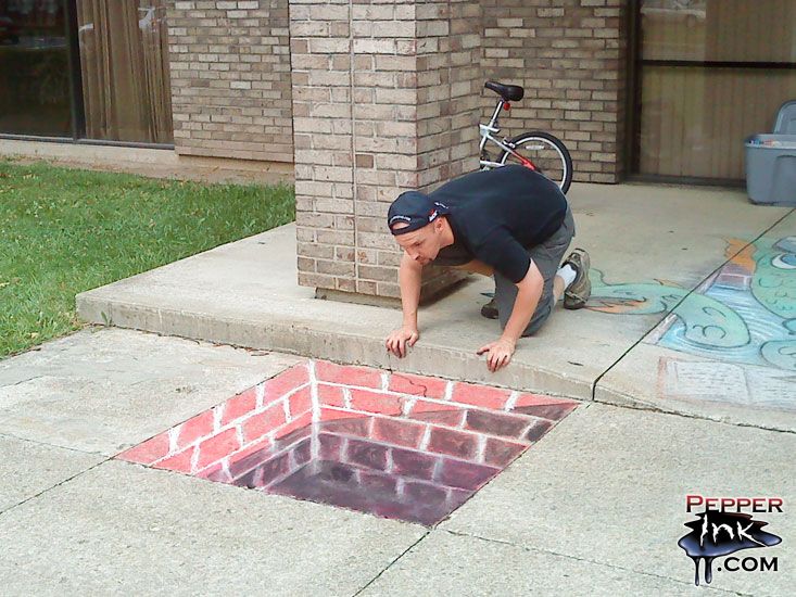 a man is bending over to look at a hole in the sidewalk