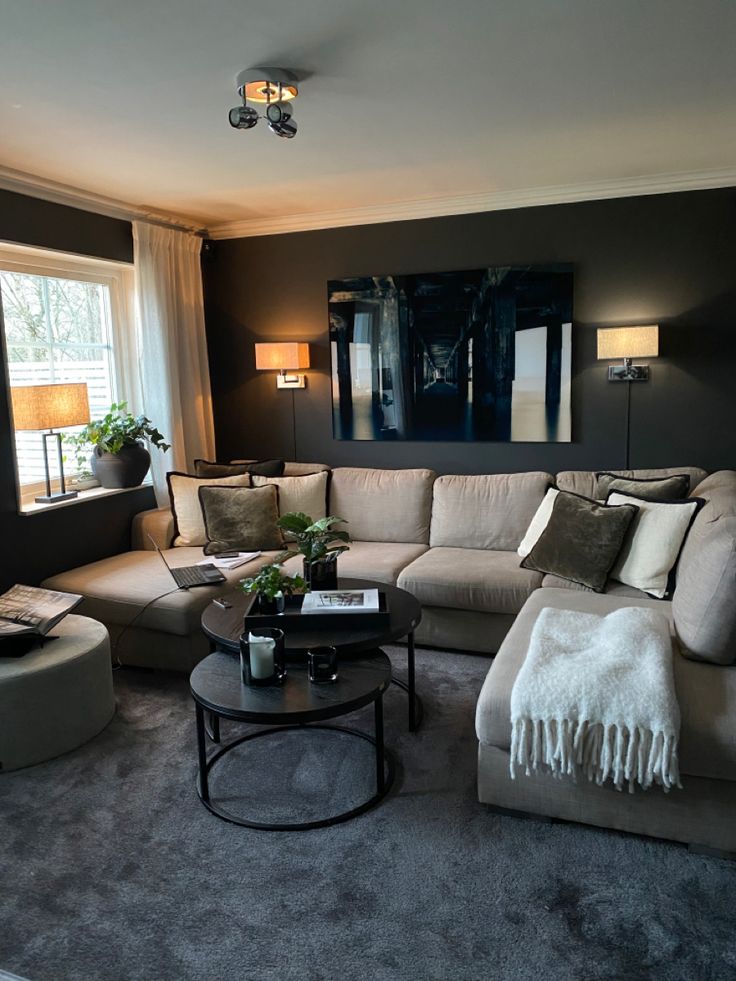 a living room filled with lots of furniture and a painting on the wall behind it