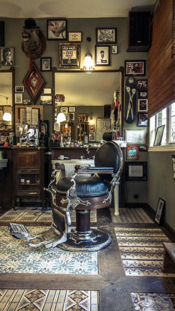 an old fashioned barber shop with many framed pictures on the wall and antique chair in front