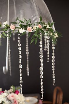 an umbrella decorated with flowers and pearls is the focal point for this elegant table setting