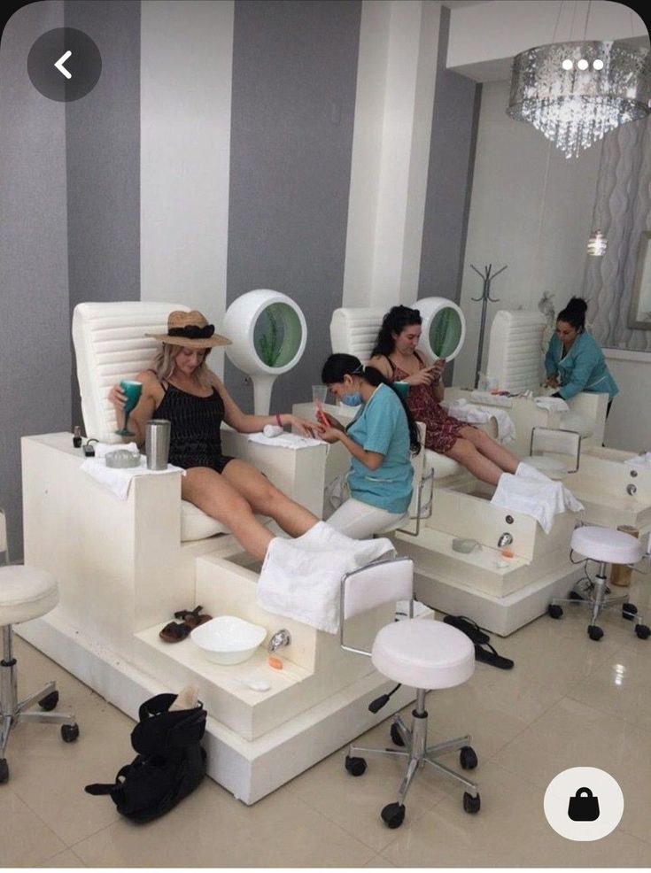 a group of people sitting on top of white chairs in a room with striped walls