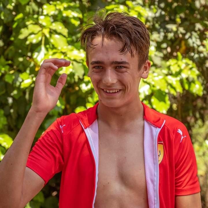 a young man with no shirt on posing for the camera and holding his hand up