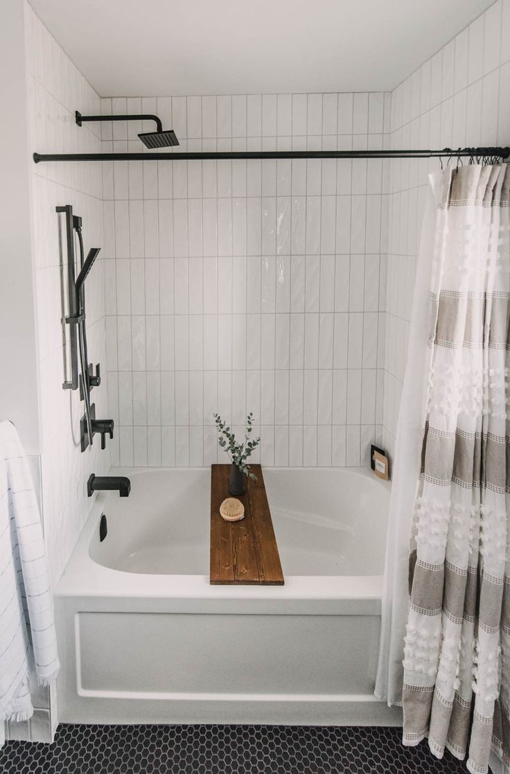 a white bath tub sitting next to a wooden cutting board on top of a counter