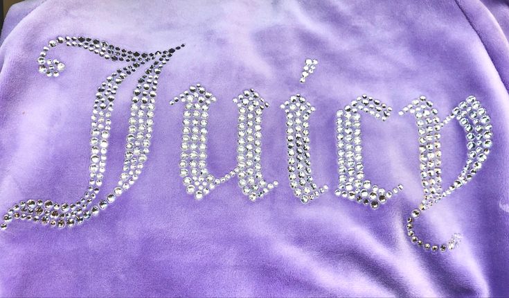 a purple jacket with the word fancy written on it, and some diamonds in the letters