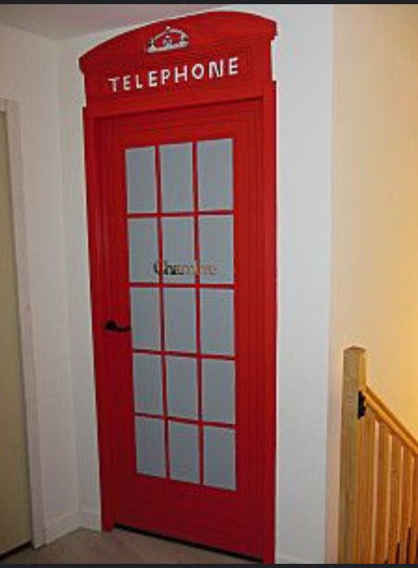 a red phone booth sitting in the corner of a room