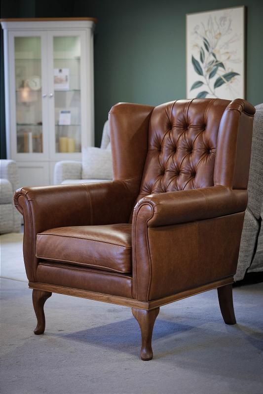 a brown leather chair sitting in a living room