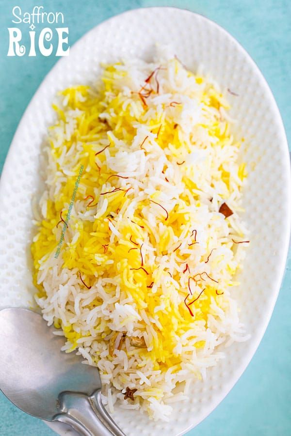 a white plate topped with rice and yellow sprinkles next to a fork