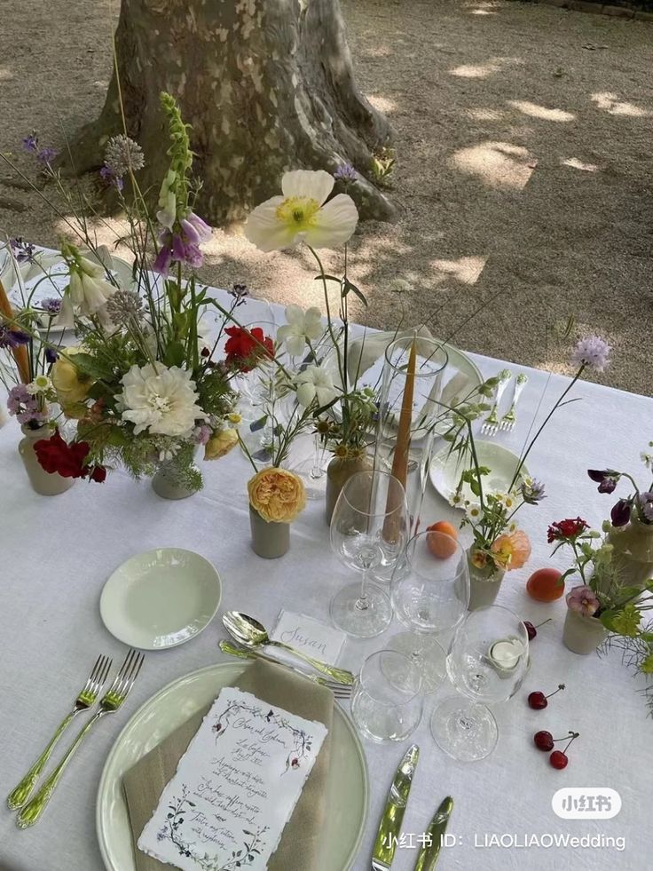 the table is set with flowers and place settings