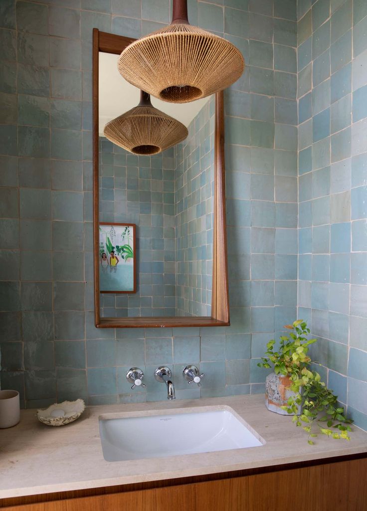 a bathroom with blue tile and wooden accents, including a bamboo fan hanging over the sink