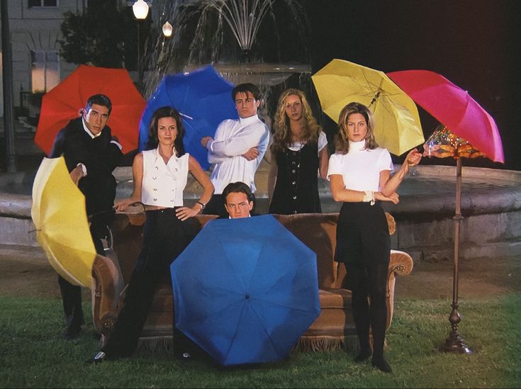 a group of people standing next to each other with umbrellas in front of them