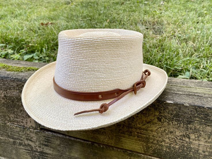 "Upgrade your favorite hat with a custom and customizable leather hat band. Perfectly adjustable to fit any size hat and can be secured in multiple ways to customize your style. Each hat band is handmade from substantial and durable full-grain vegetable tanned leather. Made to your order, the leather is cut, dyed, and finished. The edges are then beveled, burnished, and sealed for a smooth feel. Bands are 5/8\" wide. Sizes are based on the length of the wide part of the leather and can fit a ran Adjustable Leather Top Hat With Curved Brim, Western Style Adjustable Top Hat For Outdoors, Classic Natural Hat Bands For Outdoor, Adjustable Leather Panama Hat With Short Brim, Natural Hat Bands For Kentucky Derby, Adjustable Country Style Top Hat For Outdoor, Adjustable Leather Hat Bands With Flat Brim, Classic Adjustable Hat With Leather Sweatband, Classic Hat With Adjustable Leather Sweatband