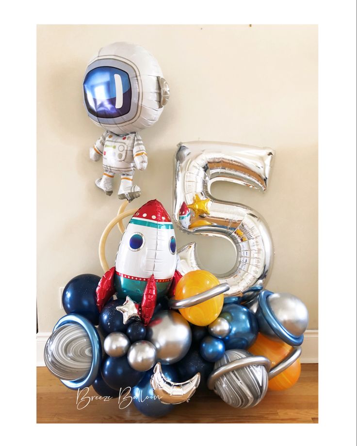 a bunch of balloons that are in the shape of an astronaut's helmet and number five