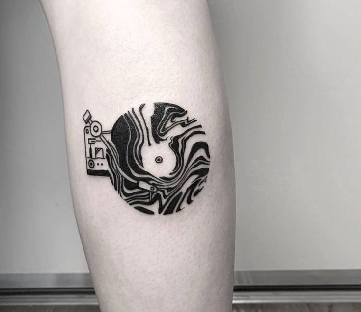 a black and white photo of a person's leg with a tattoo on it