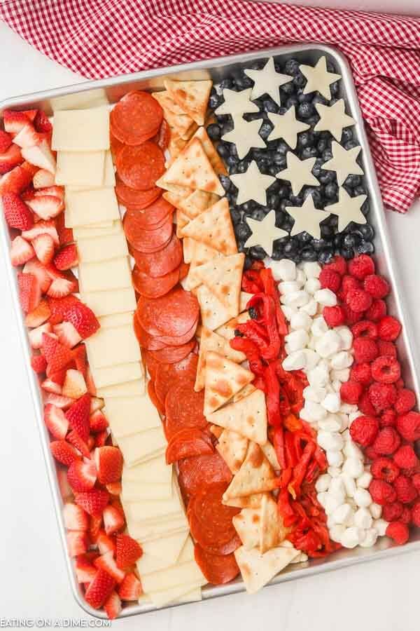 an american flag made out of pizza and strawberries in a tray on a table