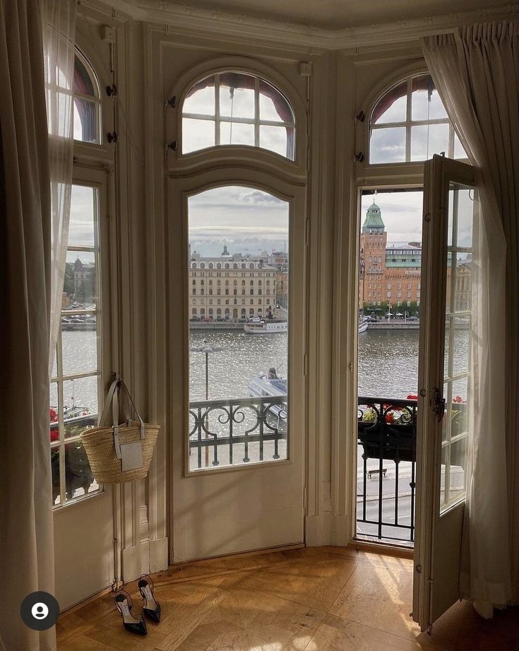 an empty room with large windows overlooking the water