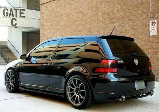 a black car parked in front of a brick building