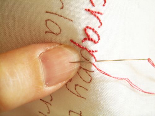 someone is stitching on the fabric with a needle and thread in their left hand