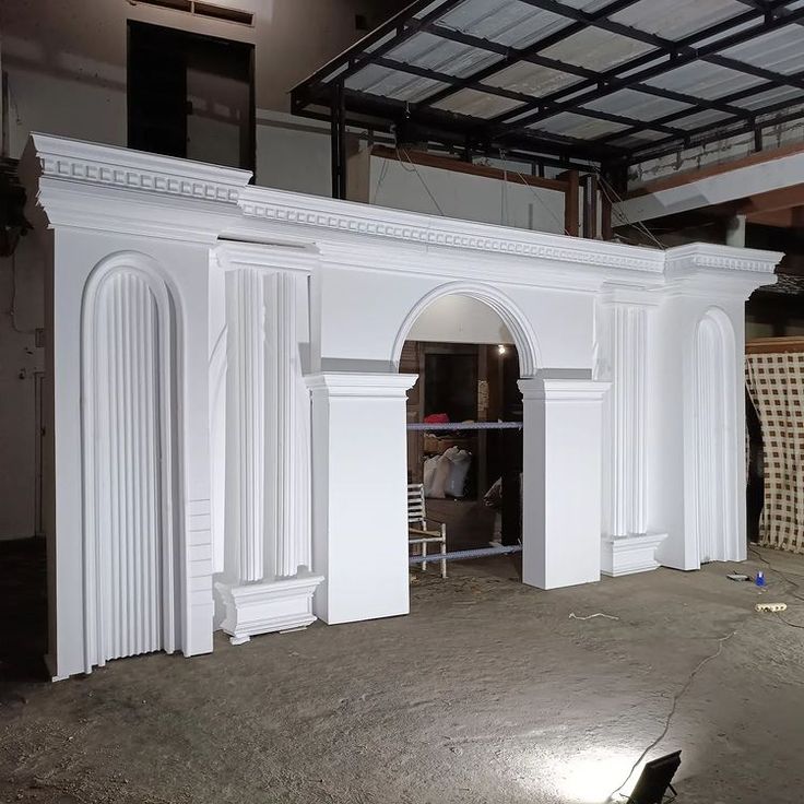 an unfinished room with white columns and arches