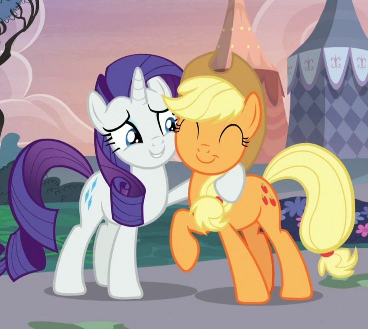 two little ponys standing next to each other in front of a castle