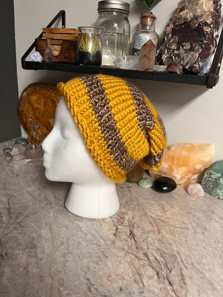 Hand stitch with heart, this slouchy beanie is the perfect blend of soft and thick.  A beautiful blend of yellow and variegated brown yarn, it's perfect for staying cozy on cold days.  -Slouchy Style -Adult Size Small -Hand knit & made in the U.S.A -Made with acrylic yarn -Fits head circumference 20in -Hand wash cold with like colors and air dry. Casual Slouchy Yarn Beanie, Brown Slouchy Casual Beanie, Casual Brown Slouchy Beanie, Casual Slouchy Brown Beanie, Brown Knit Crochet Hat One Size, Casual Slouchy Brown Hat, Slouchy Acrylic Yarn Beanie For Fall, One Size Brown Crochet Hat With Soft Knit, Handmade Brown Casual Beanie