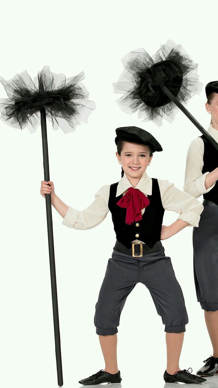 two children dressed up in costumes and holding black pom - poms, posing for the camera