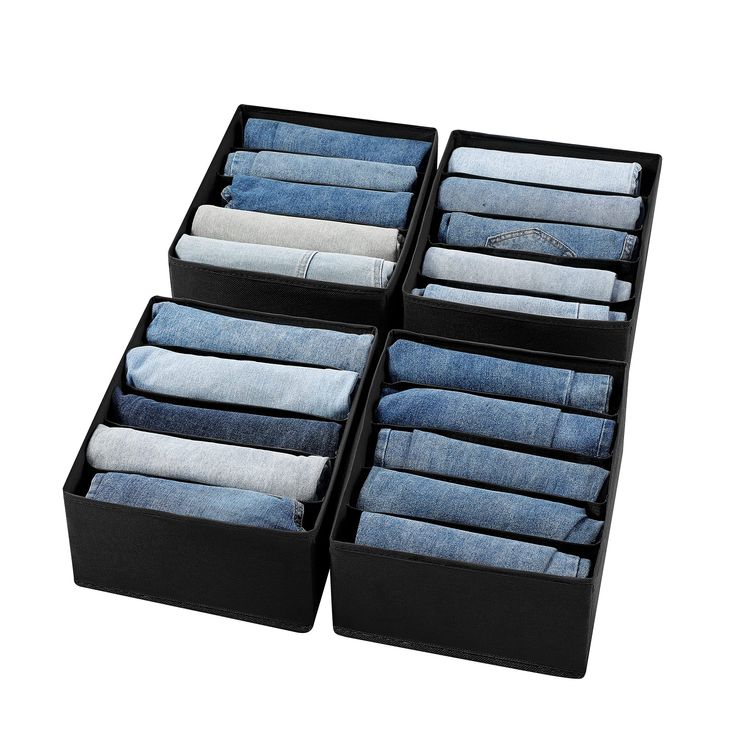 four pairs of jeans are stacked in a black box on top of eachother