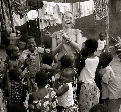 a woman standing in front of a group of children