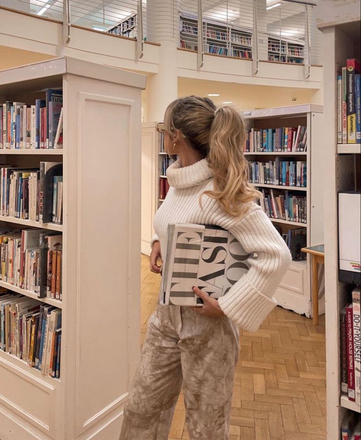 a woman standing in front of a bookshelf with a book on her back