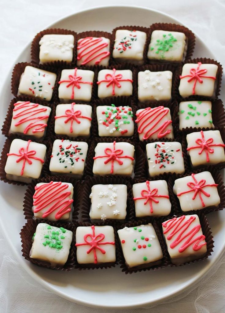 a white plate topped with lots of cookies covered in frosting and candy canes