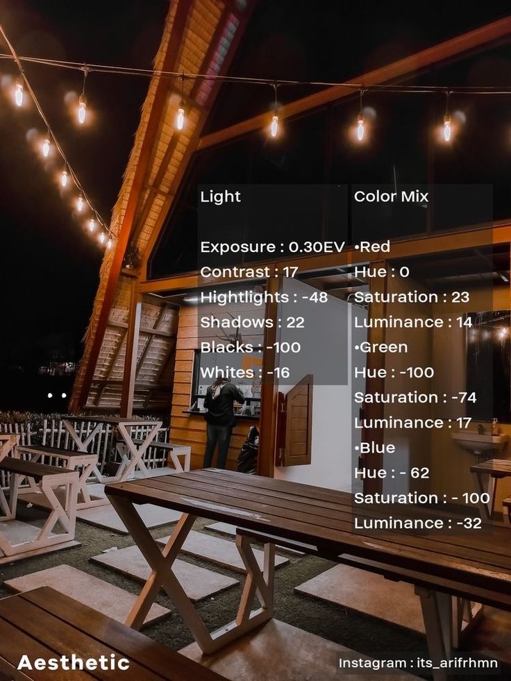 a wooden table sitting on top of a roof covered in lights and string lights above it