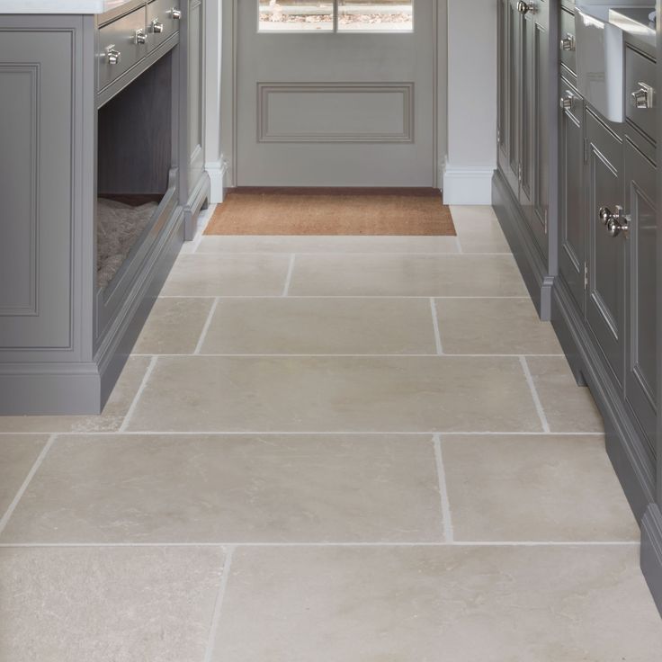 a kitchen with gray cabinets and white counter tops