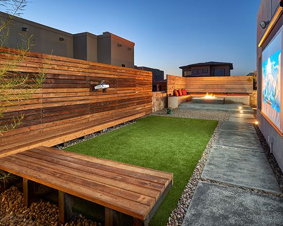 a wooden bench sitting on top of a grass covered field next to a fenced in area