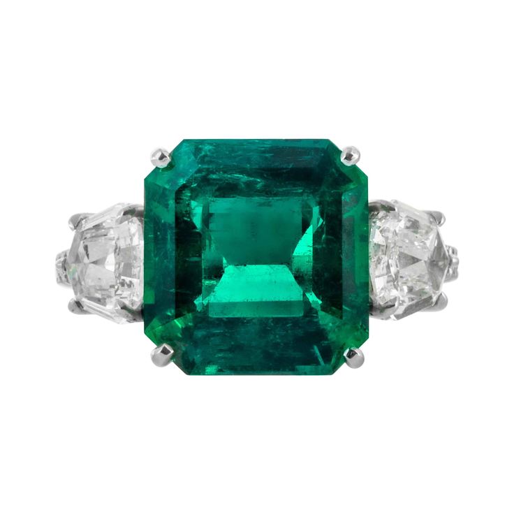 This emerald ring is offered by Shreve, Crump & Low. This green emerald cut emerald is custom set in a handcrafted Shreve, Crump & Low one-of-kind platinum ring, consisting of 1 Colombian green emerald cut emerald weighing 5.48 carats. This 5.48 carat center stone is accented by 2 step cut kite shaped diamonds with round brilliant cut diamond gemset down the sides of the ring totaling 1.72 carats. The setting is a ring size 6.5, and is inscribed with our maker's hallmark "SC&L" "PLAT" and our se Antique Cocktail Ring, Sapphire Solitaire Ring, Emerald Cut Diamond Ring, Tanzanite Diamond Ring, Platinum Diamond Rings, Retro Ring, Colombian Emeralds, Diamond Cocktail Rings, White Gold Diamond Rings