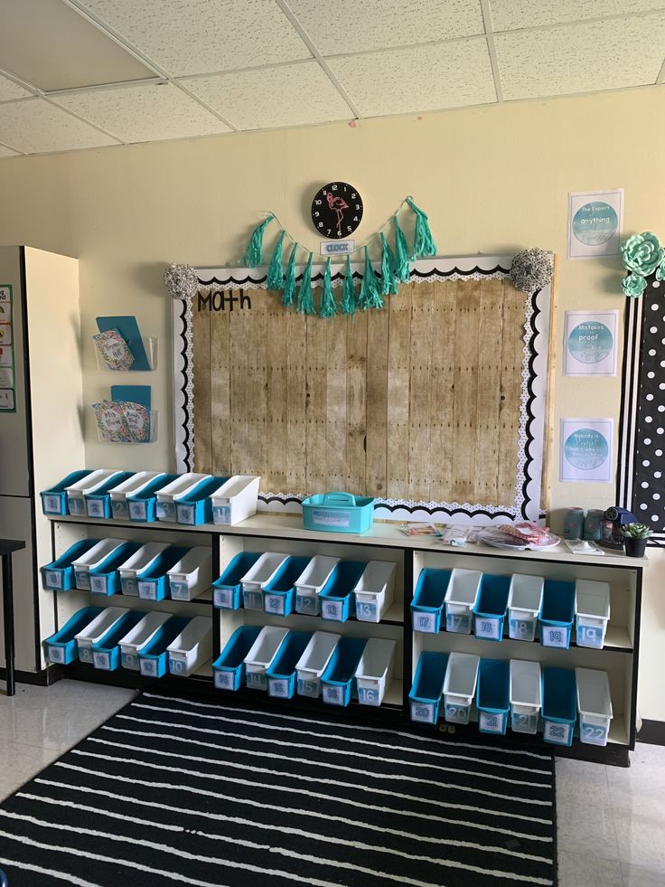 an organized classroom with blue boxes on the floor and a bulletin board in the background