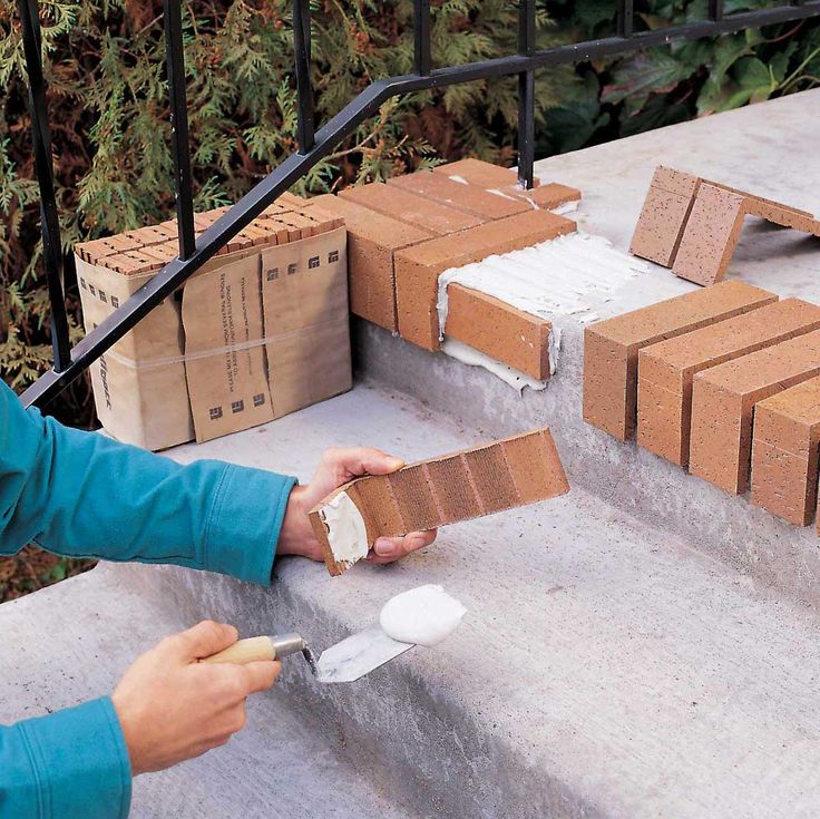 a woman is painting some bricks on the steps