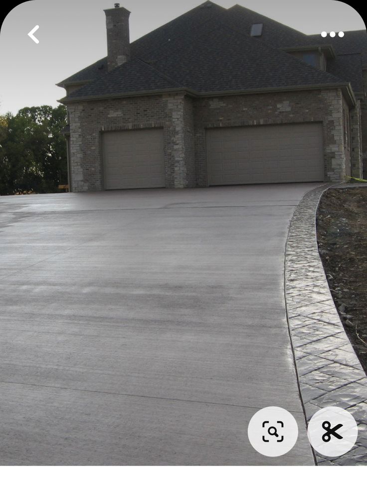 a person riding a skateboard in front of a large house with two garage doors