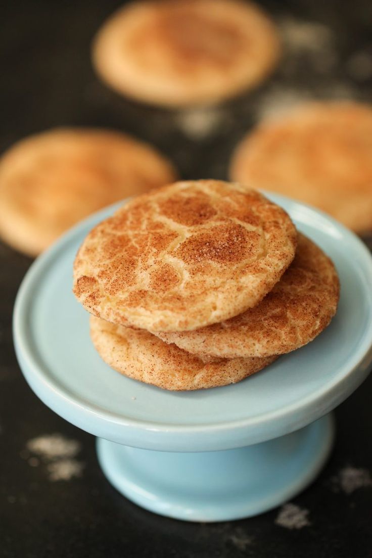 three pancakes sitting on top of a blue plate next to other small ones in the background