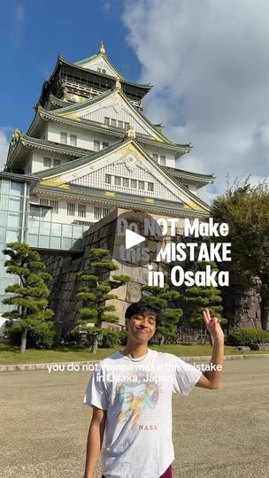 a man standing in front of a tall building with the words don't make mistake in osak