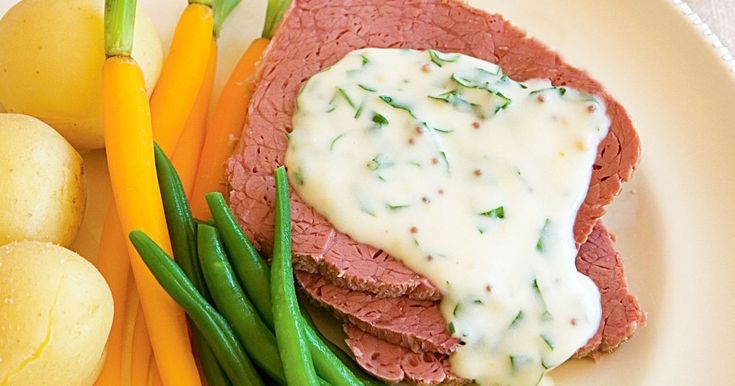 a white plate topped with meat, potatoes and green beans