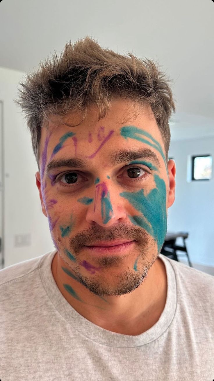 a man with his face painted in blue and pink