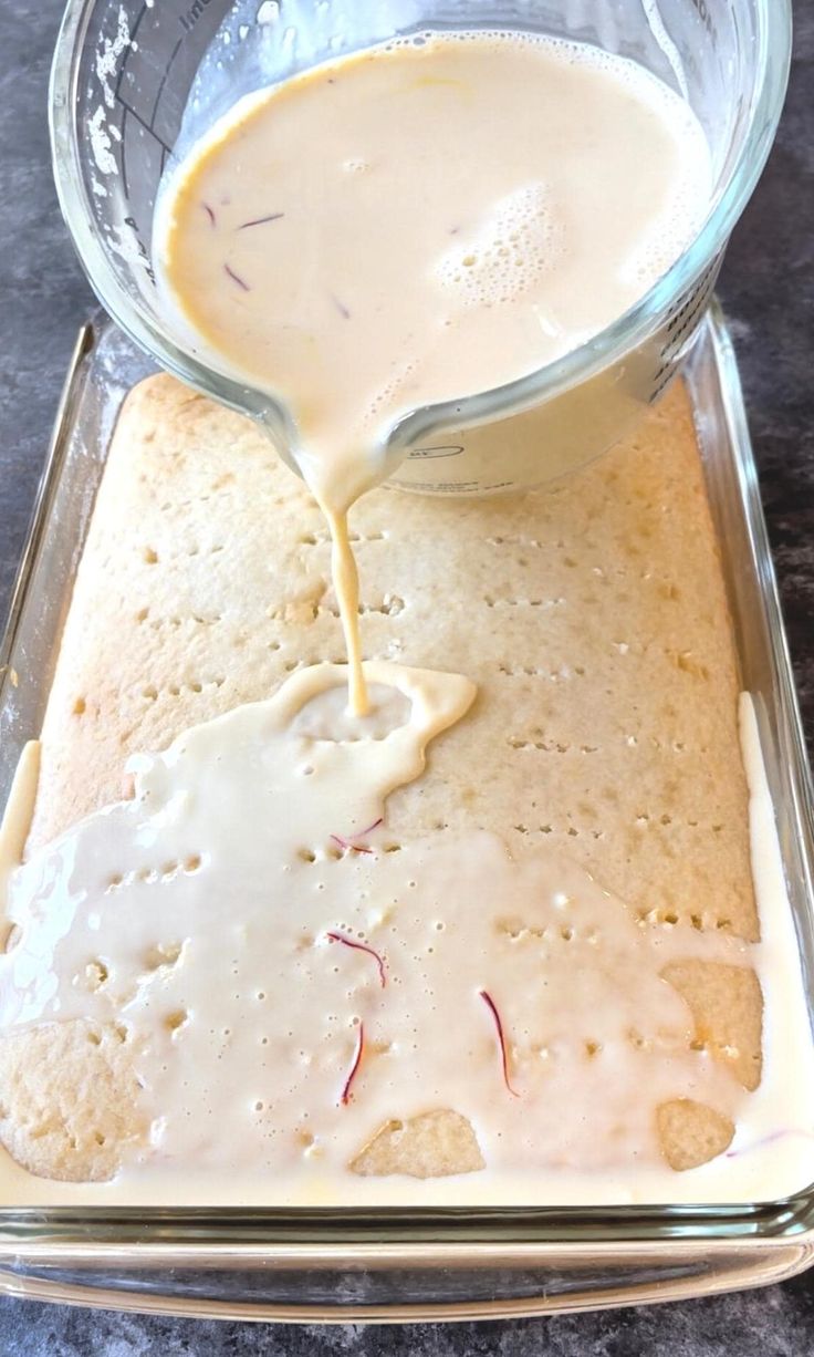 a pan filled with cake batter being poured into the baking dish to bake it