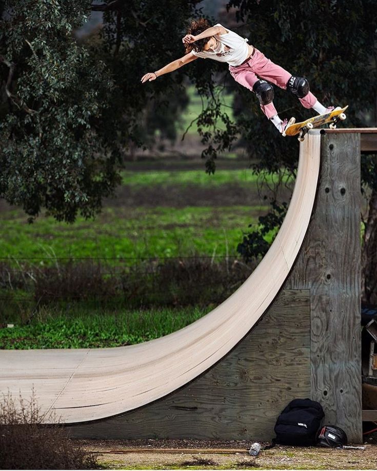 a man riding a skateboard up the side of a wooden ramp