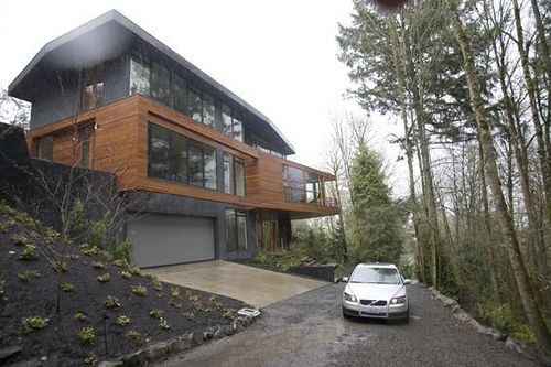 a car is parked in front of a large house on the side of a road